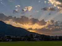 Sonnenuntergang rechts vom Aschauer Berg mit Sonnenstrahlen